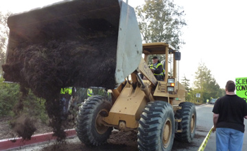 bulldozer full of manure menaces protesters